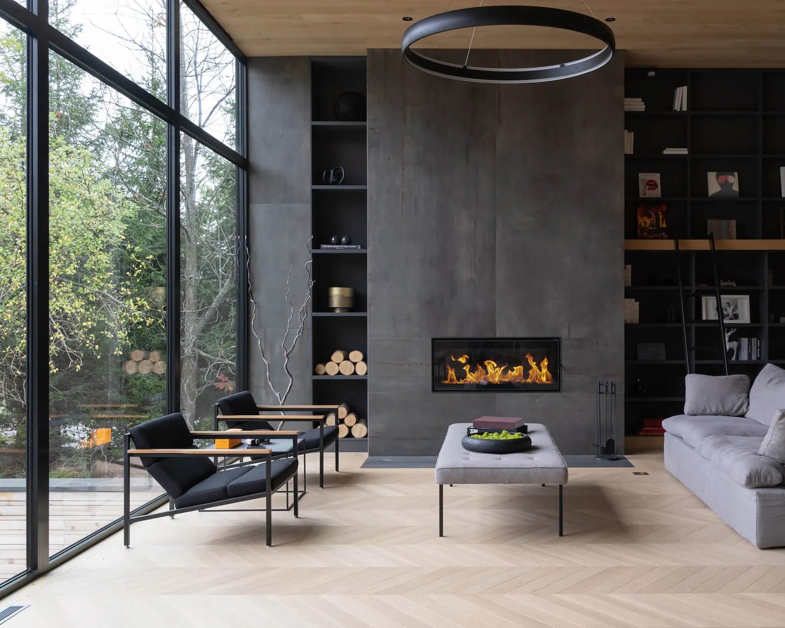 A modern Toronto living room with floor-to-ceiling glass and a linear fireplace, presented by The Central